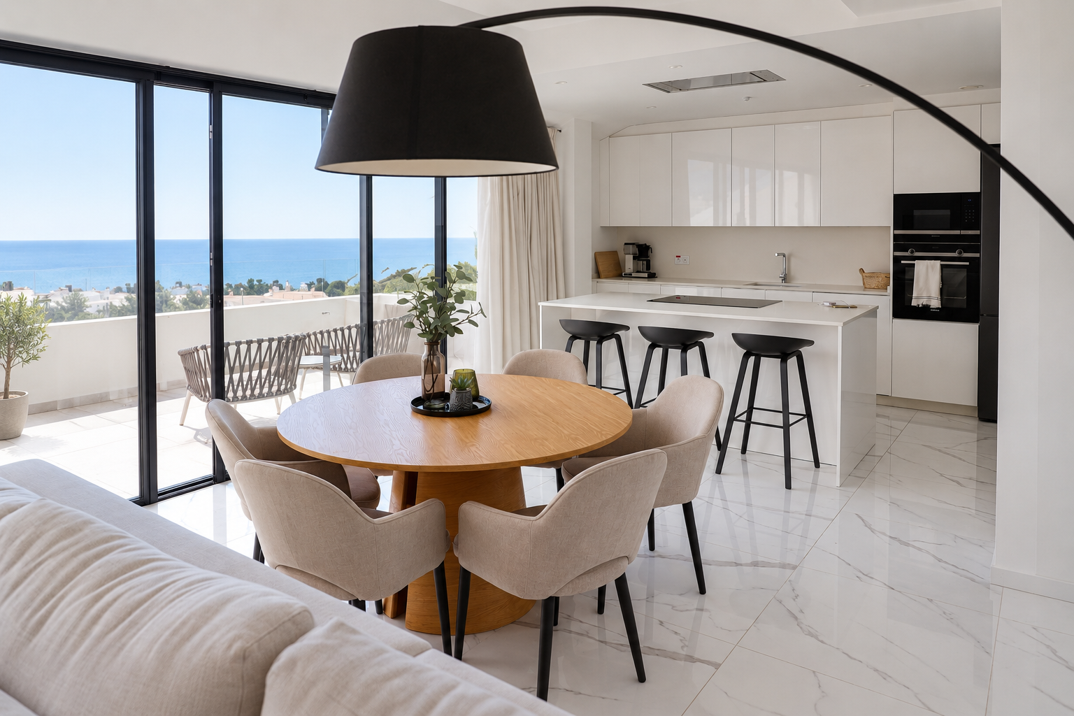 Open-plan dining area and white kitchen with the Mediterranean Sea beyond at The View Fuengirola