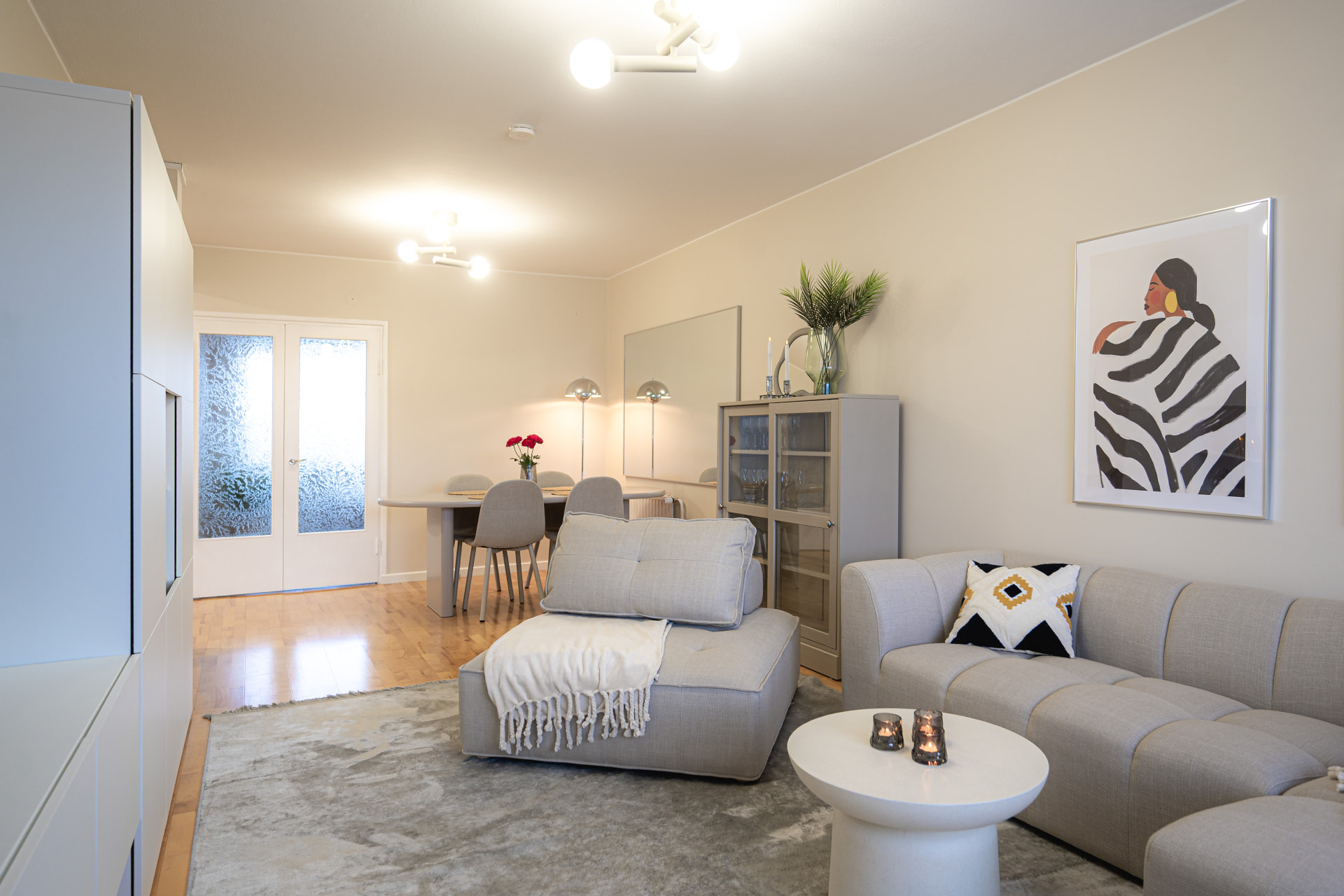 Light living room with a grey sofa and dining area beyond at Satamahovi